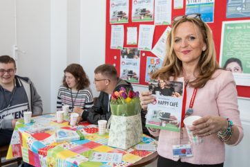B58A6458 staff member holding Happy Cafe leaflet