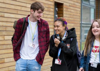 CG Extra 3 students walking outside a campus building