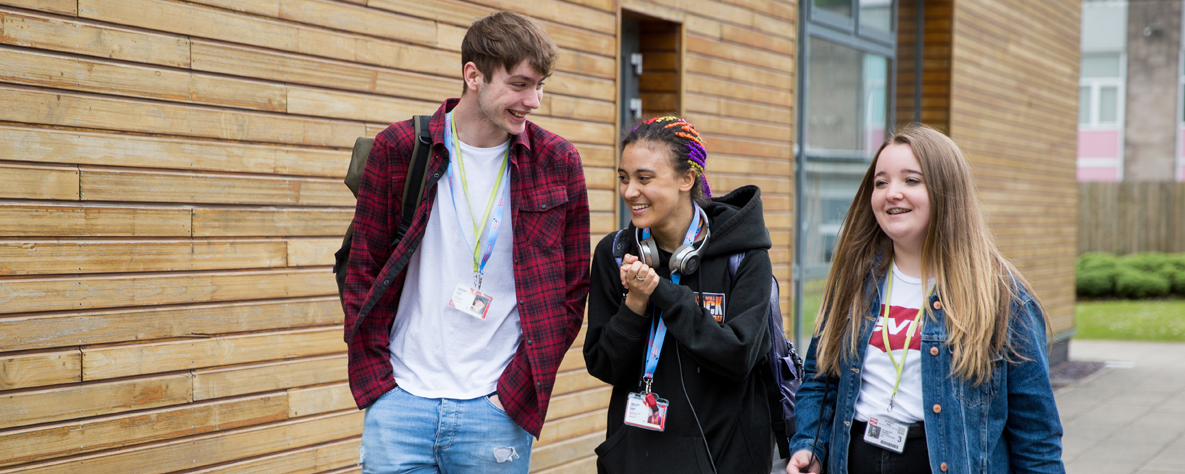CG Extra 3 students walking outside a campus building