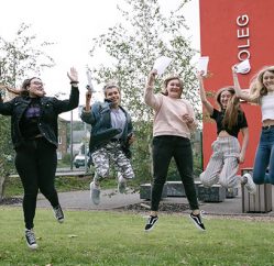 students celebrating outside campus