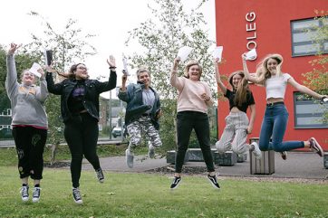 Eve-Mainwaring-Eve-Mansfield-Cerys-Godlington-Daisy-Gibbons-Caitlin-Williams-Anna-Bateman-2 students celebrating outside campus