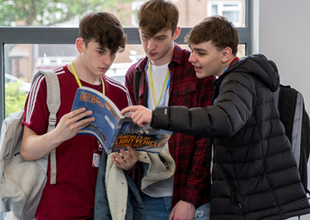Open Event 3 students looking at a book