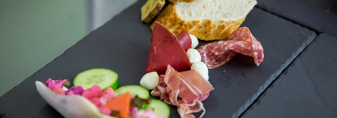 Charcuterie and salad on a slate platter
