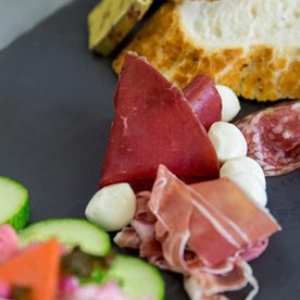 slate platter with bread, meat , cheese and salad