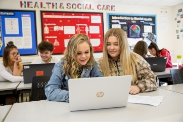 Health and social care students learning about mental health on a laptop