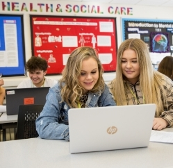 Health and social care students learning about mental health on a laptop