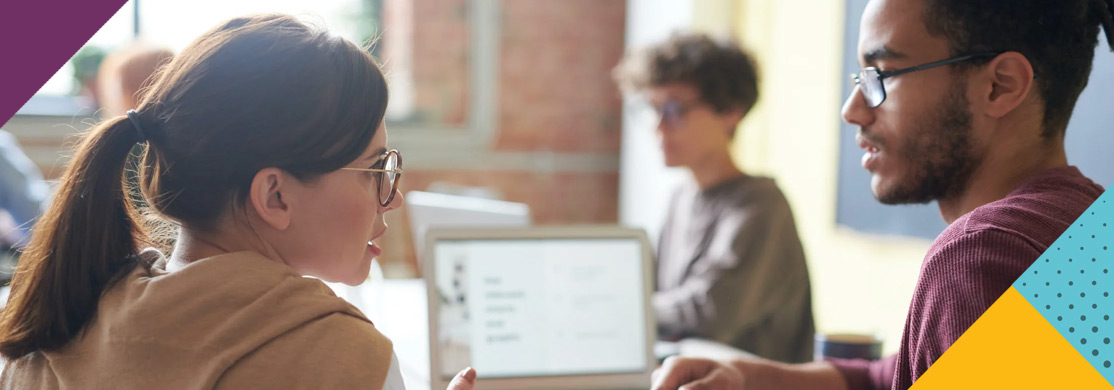 digital-marketing-sector-header Two young people talking in front of laptop