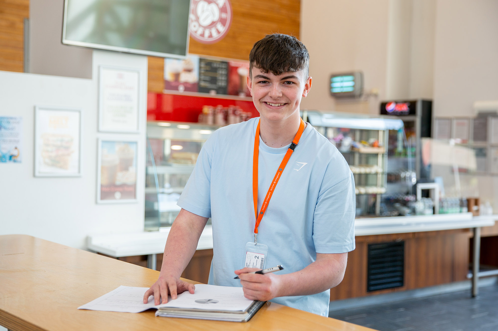 Learner smiling holding a pen