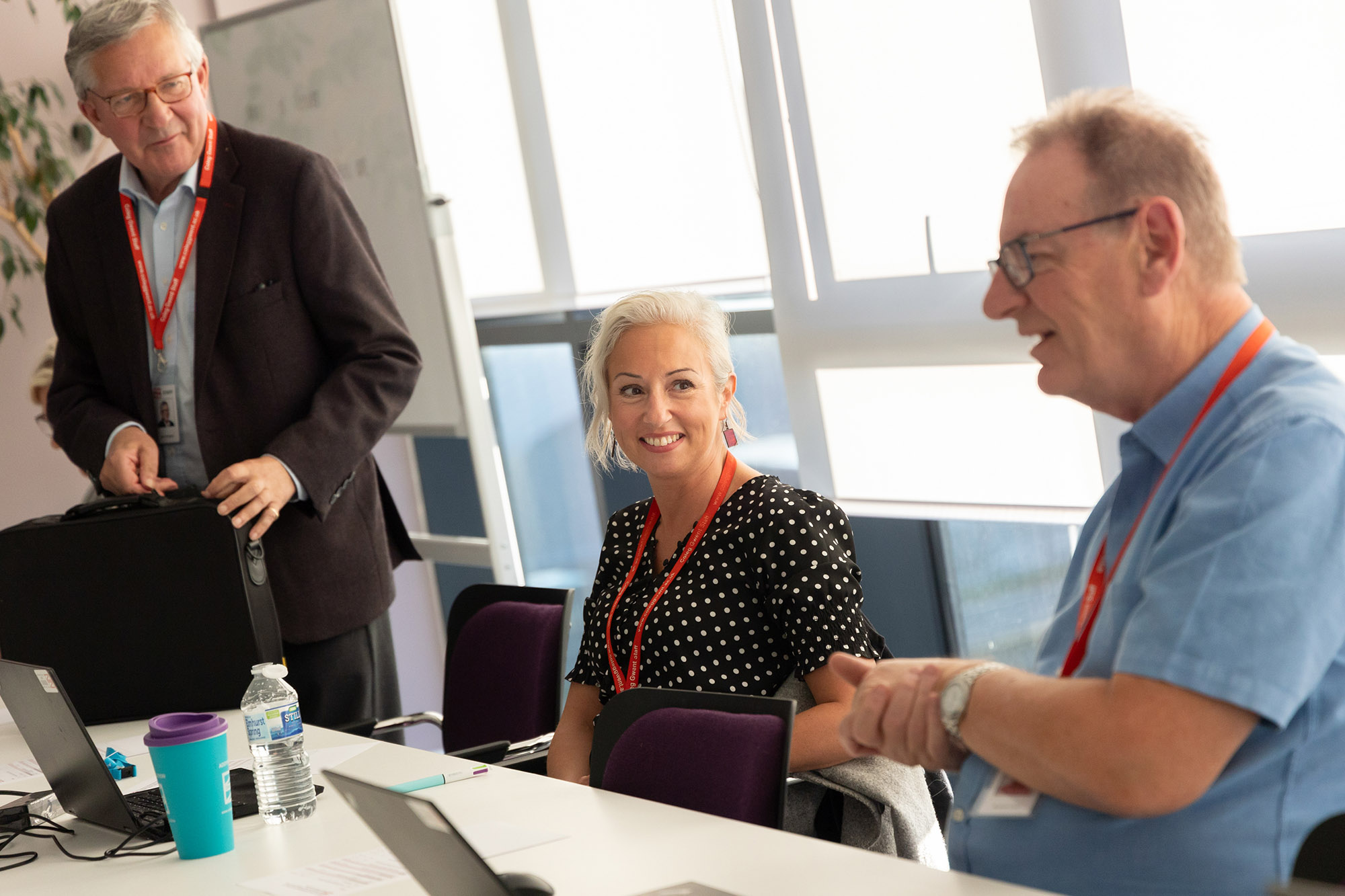 Three staff talking at governance meeting