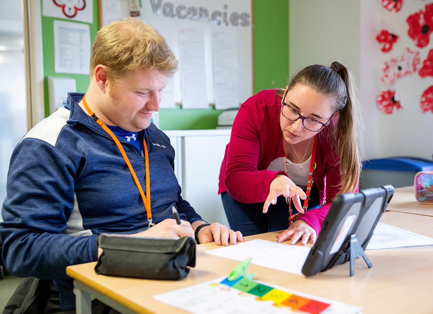 CG member of staff helping a learner with their work.