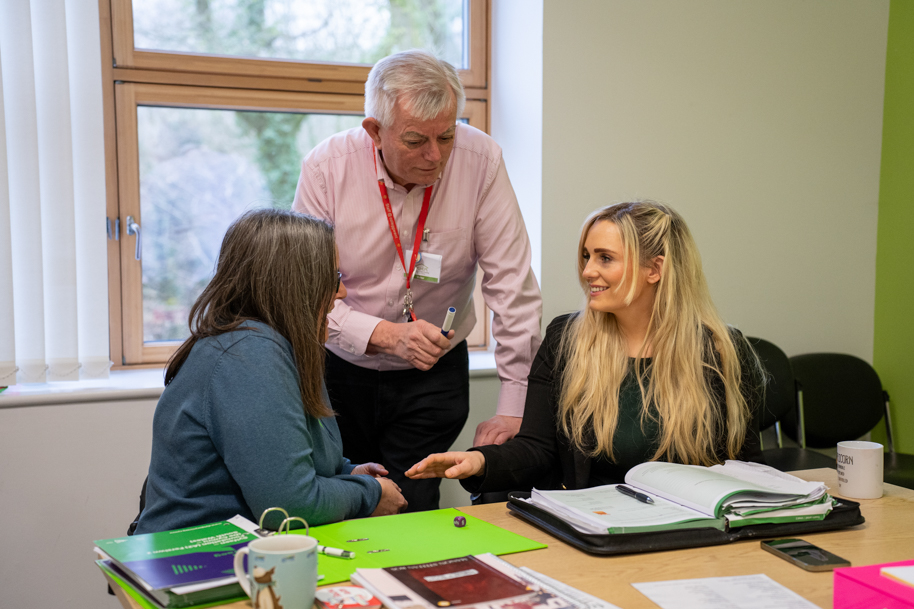 Adults learning Welsh with tutor at work