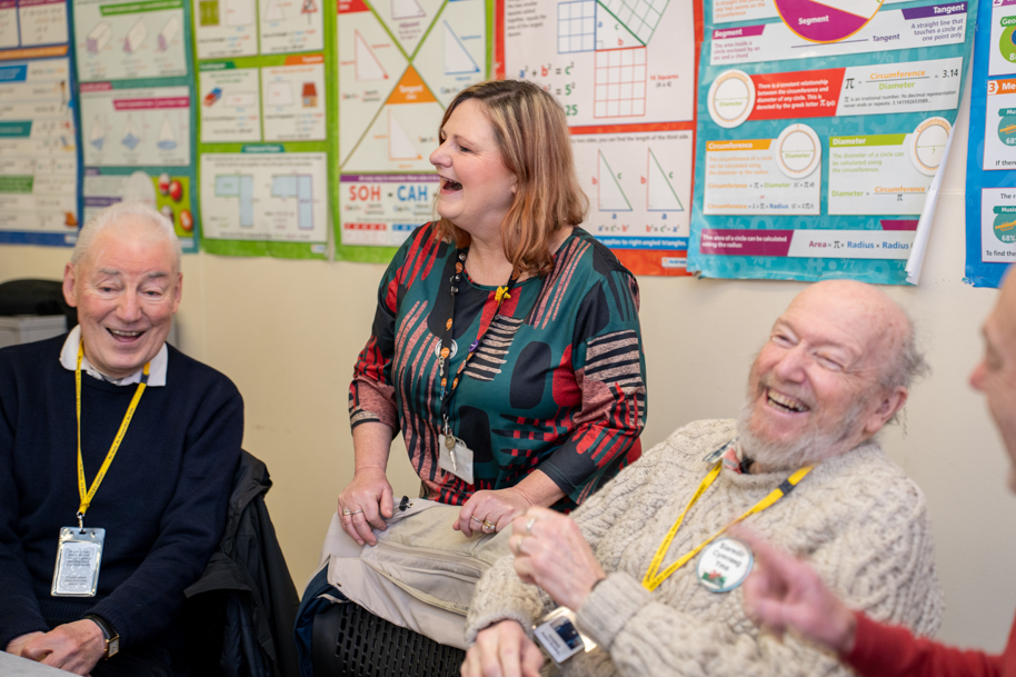 Welsh for adults tutor and students in class laughing