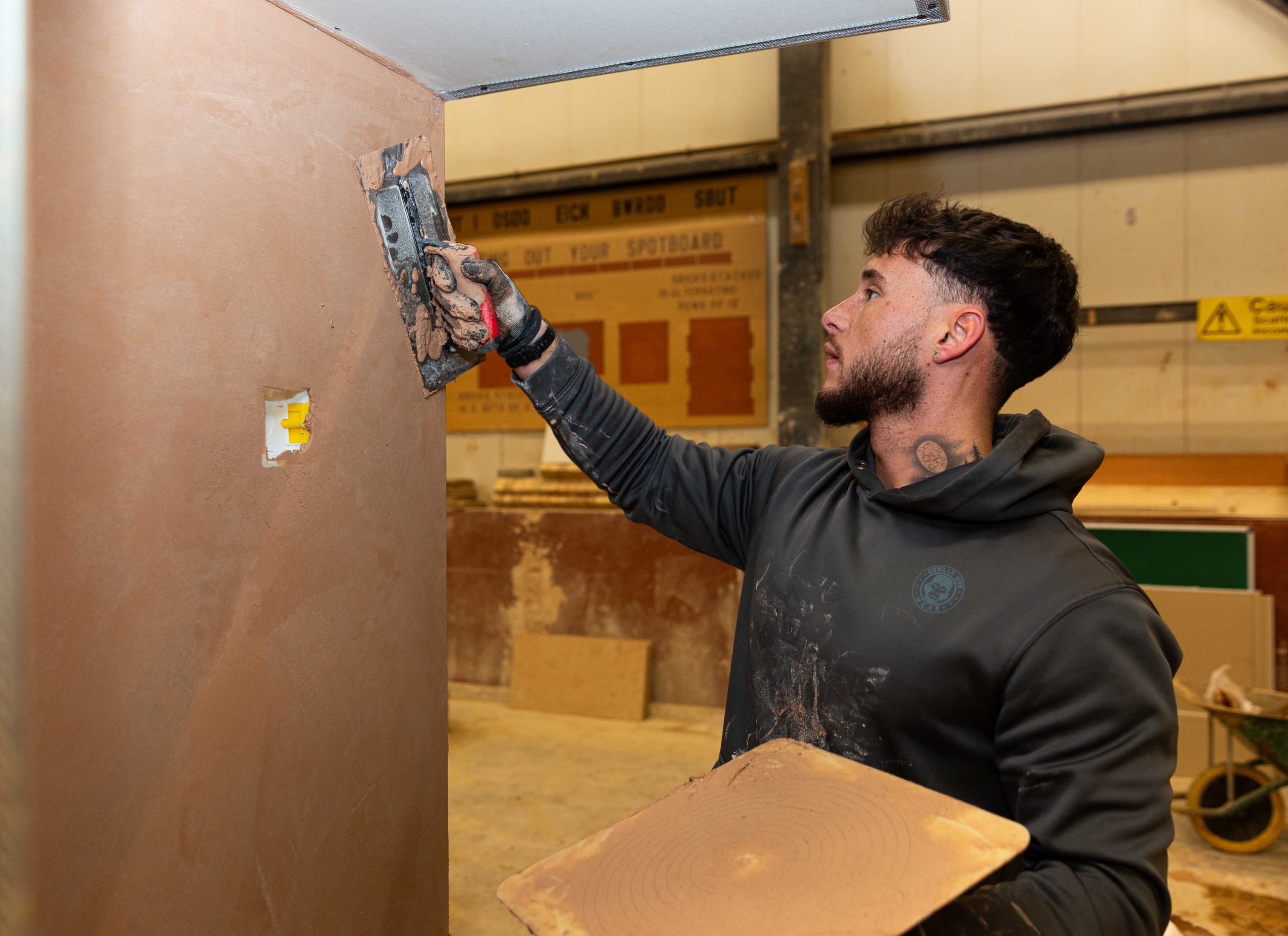 Student plastering a wall