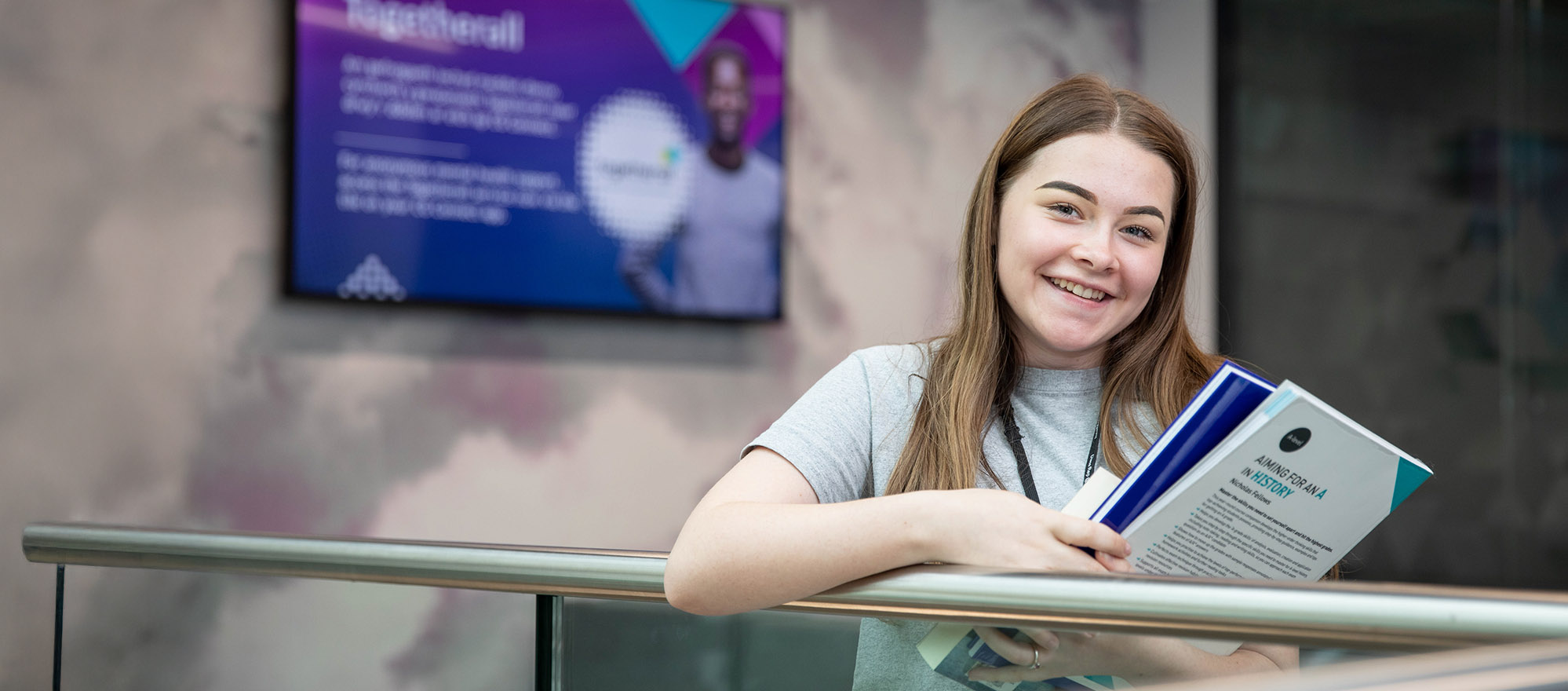 Student smiling holding books