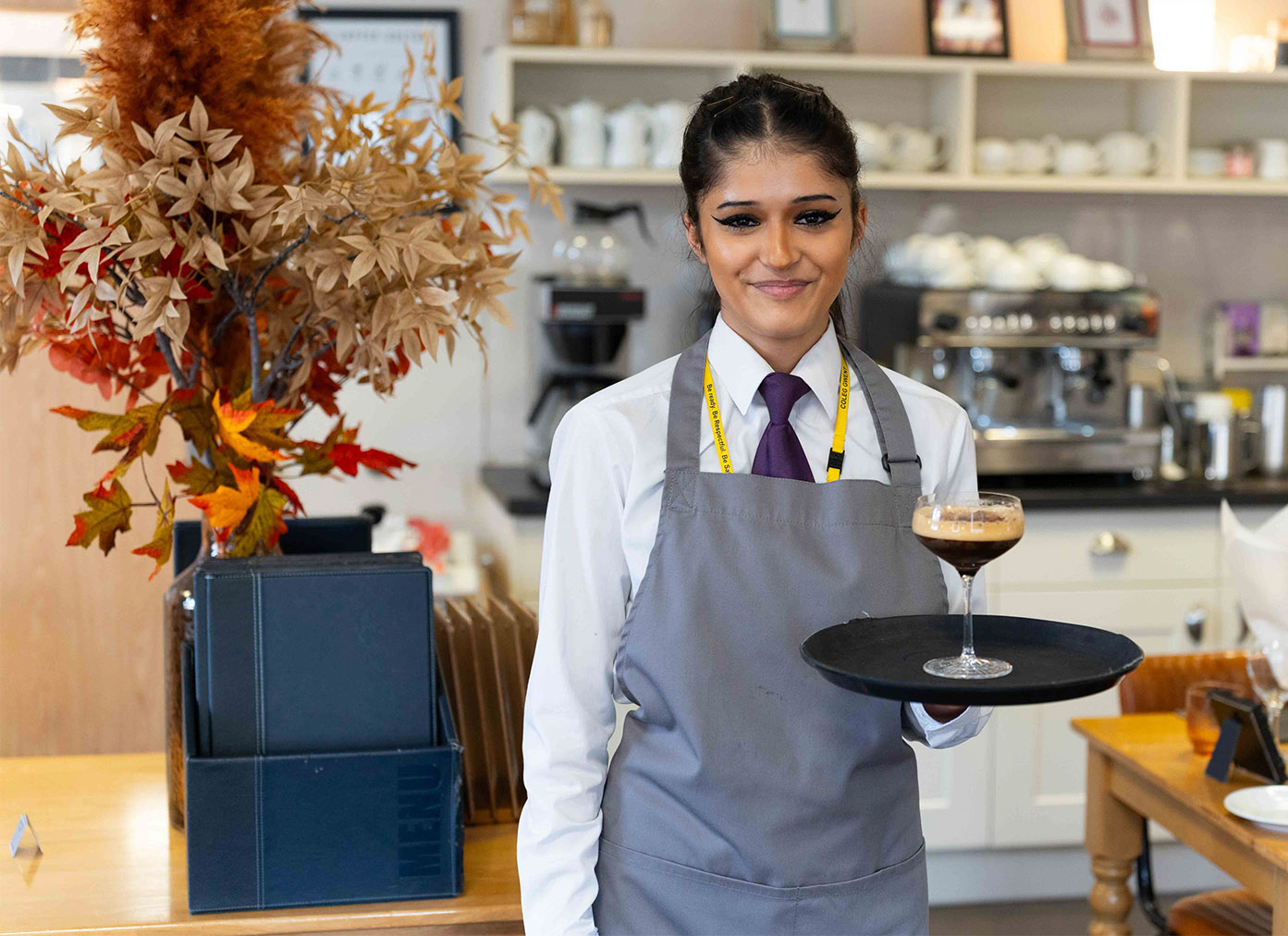 Hospitality student carrying a drink at Morels restaurant