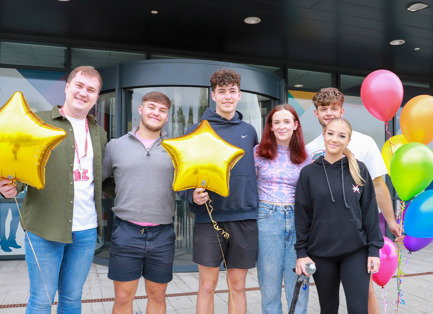 Students celebrating with balloons outside TLZ campus