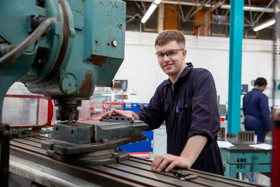Mechanical Engineering student in front of machine