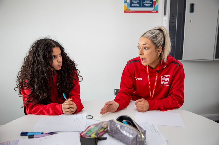 Tutor teaching student in classroom