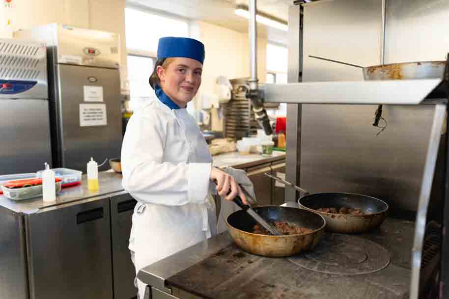 Catering student working in kitchen