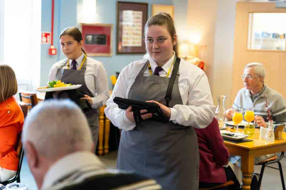 Hospitality student waitressing in Morels restaurant