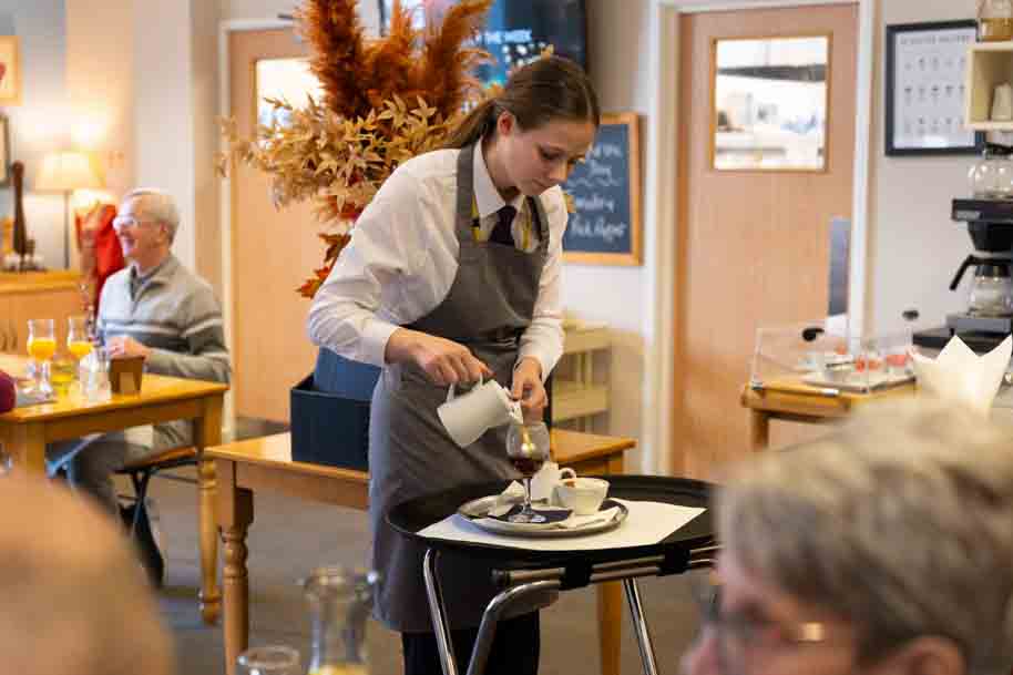 Hospitality student serving people in the restaurant