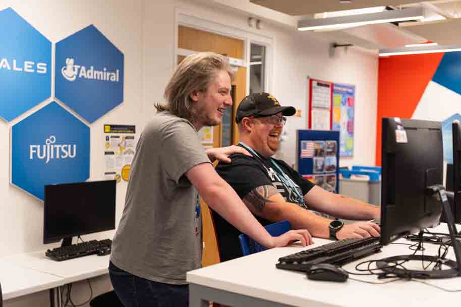 Mature students working together on PC