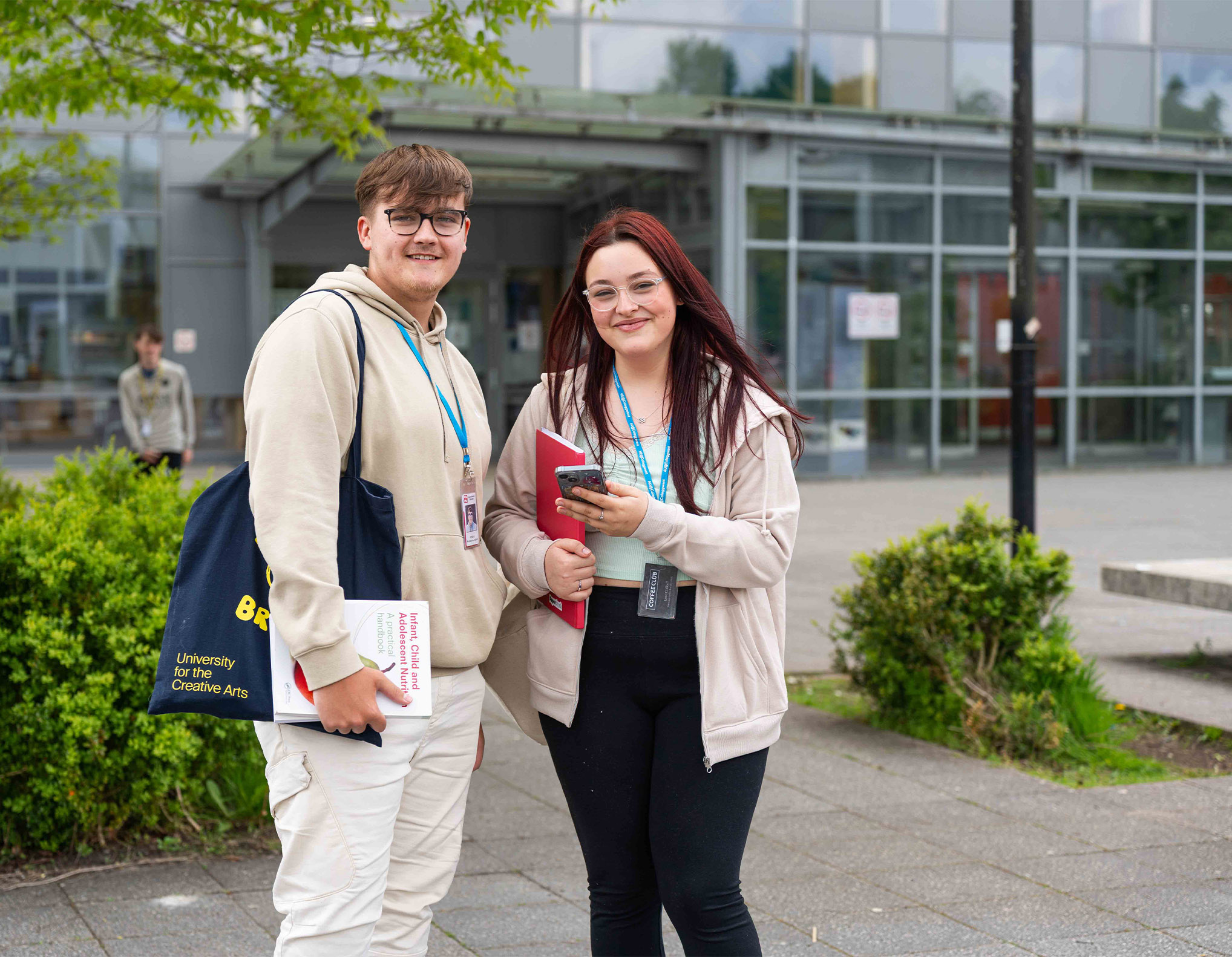 Students holding books outside Blaenau Gwent Learning Zone