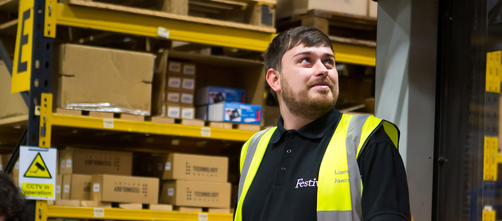 Employee in a hi vis vest operating a forklift truck