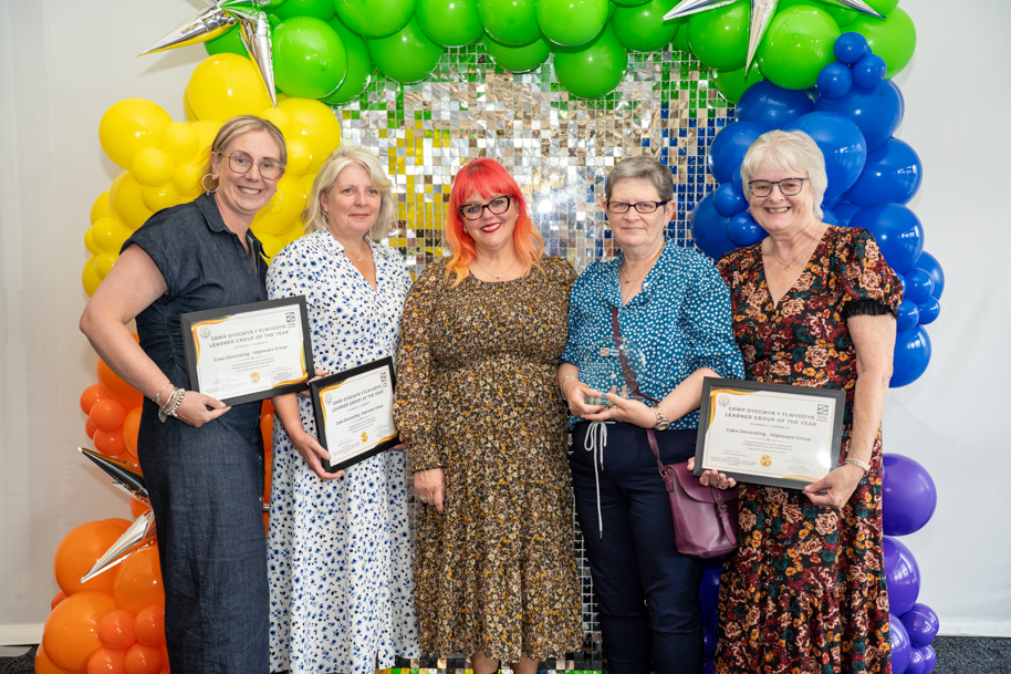 Adult learners holding an award