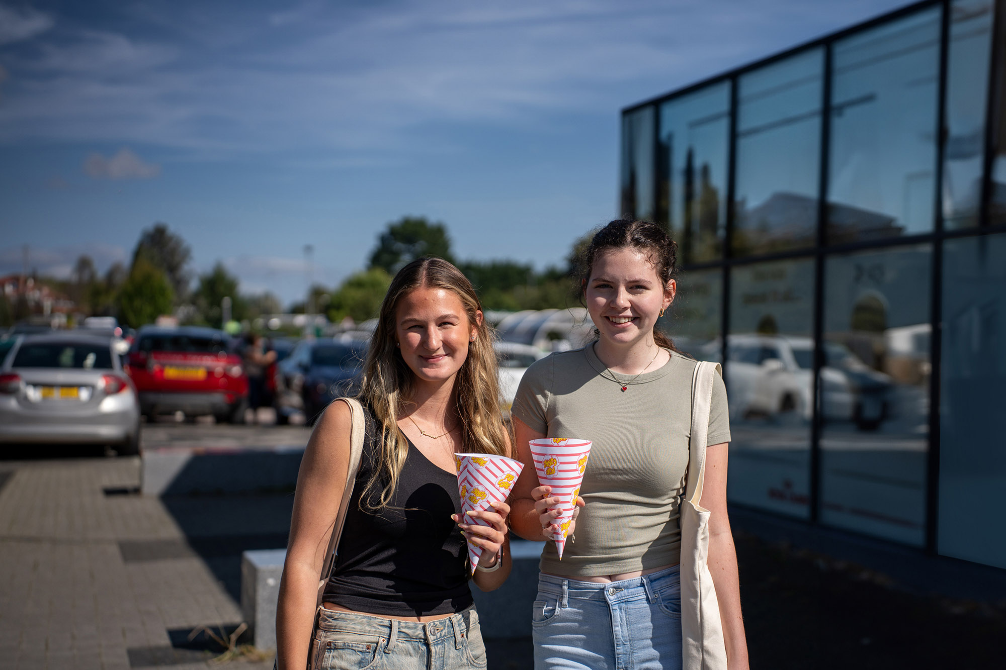Students smiling in the sunshine outside the campus