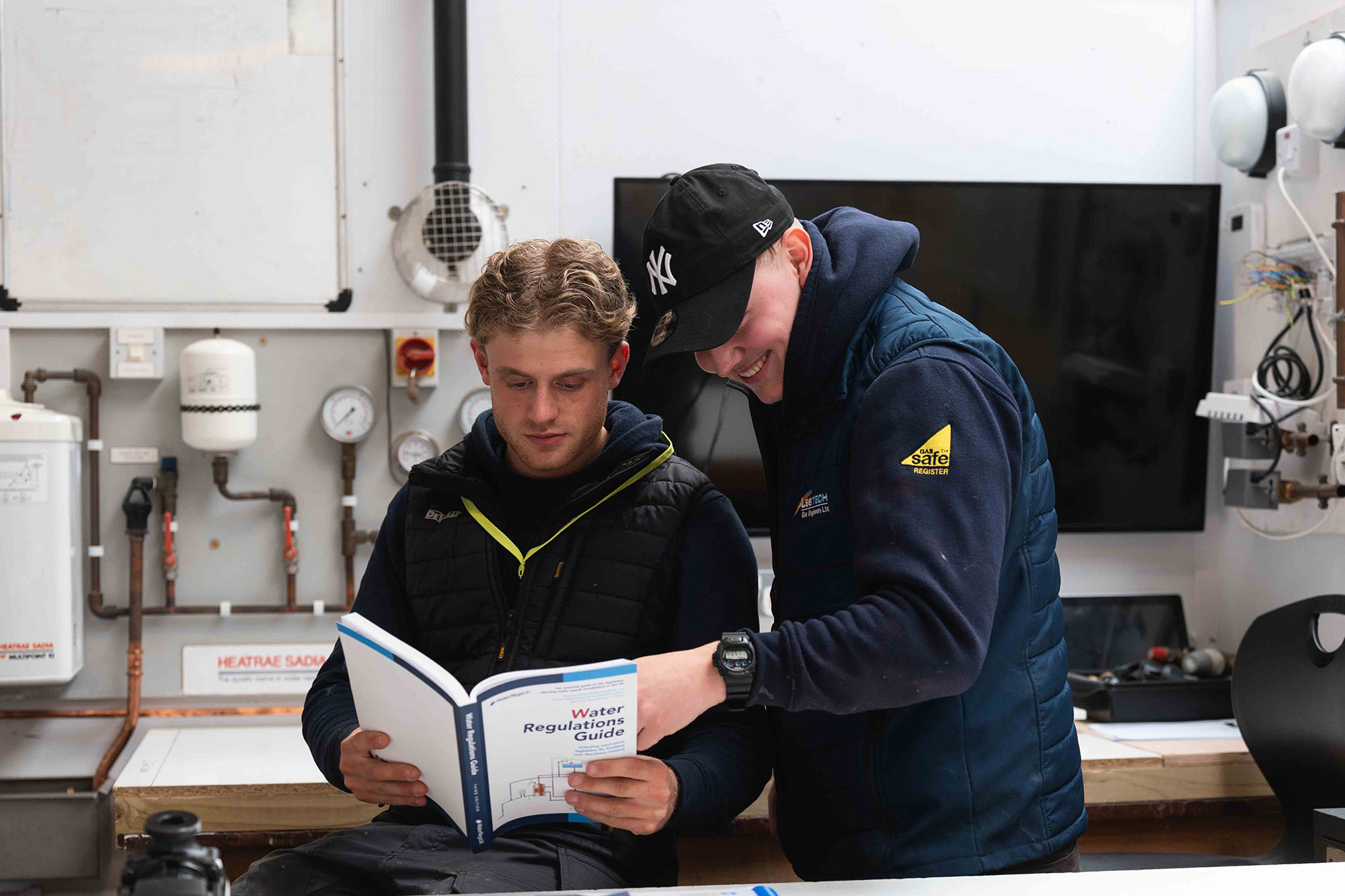 Students looking at Water Regulations Guide book